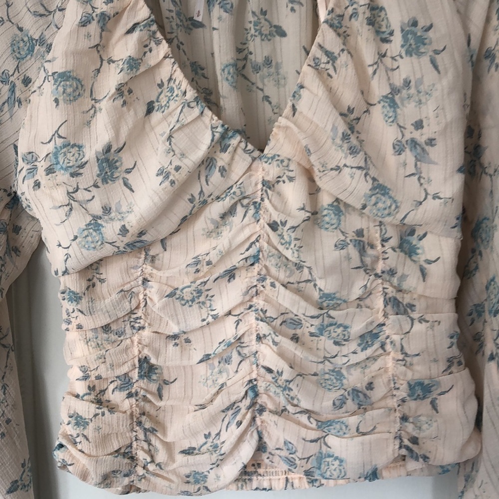 Free People size small, v- neck cropped,shirred top. Cream and blue floral. EUC